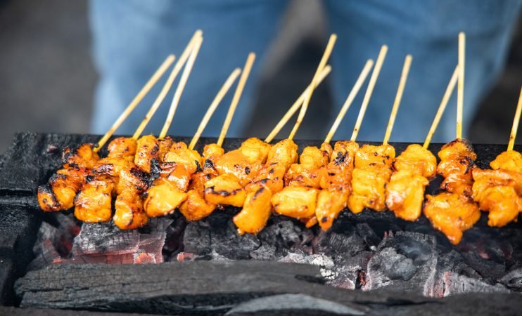 Closeup of chicken satay being barbecue with traditional pit and fired with charcoal in Malaysia